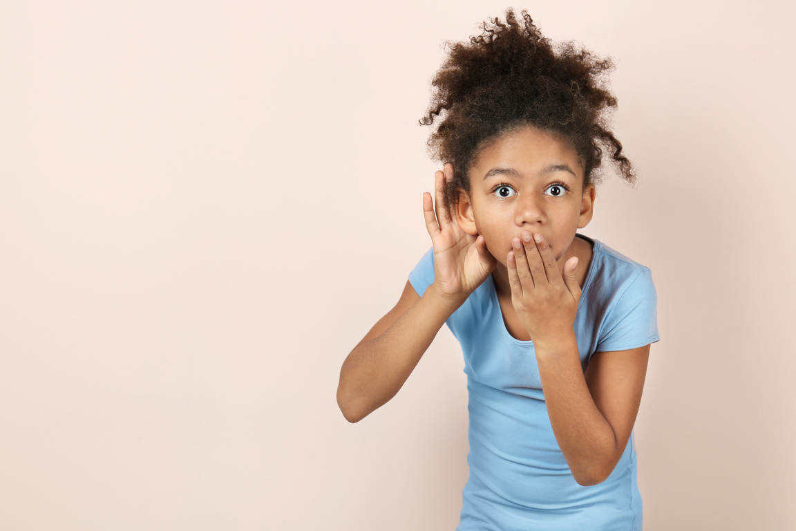 Little Girl with Hearing Problem on Brown Background